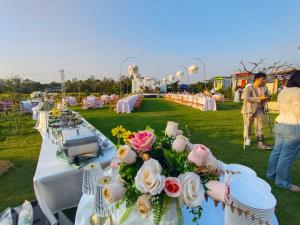 a row of tables with flowers on the grass at Bake for You Camping in Ban Nong Bua
