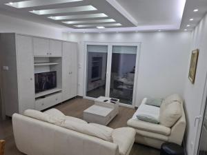 a living room with two white couches and a tv at Serbian home - free parking - Bazen se doplaćuje in Krnjača