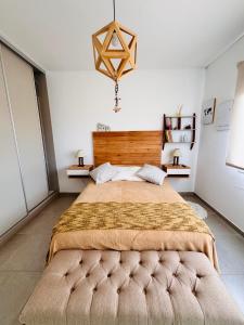 a bedroom with a large bed with a wooden headboard at Los Pirineos TC in Junín