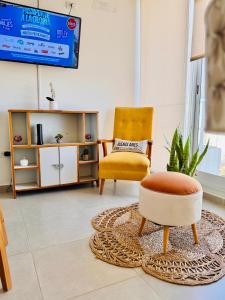 a living room with a chair and a ottoman at Los Pirineos TC in Junín