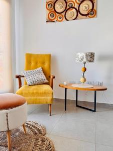 a living room with a yellow chair and a table at Los Pirineos TC in Junín +5 photos
