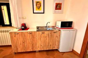 a kitchen with a sink and a microwave and a refrigerator at Your Charming Amantea Getaway in Amantea