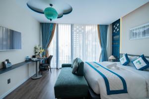 a hotel room with a large bed and a chair at Indochine Casa Hotel in Ho Chi Minh City