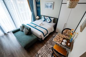 a small bedroom with a bed and a couch at Indochine Casa Hotel in Ho Chi Minh City