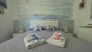 a bedroom with a bed with towels on it at Giuly Sole e Sale in Le Grazie