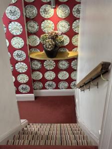 a stairway with a pot of flowers and plates on a wall at The Old Fourpenny Shop Hotel in Warwick