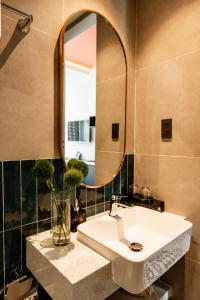 a bathroom with a sink and a mirror at Indochine Casa Hotel in Ho Chi Minh City +31 photos
