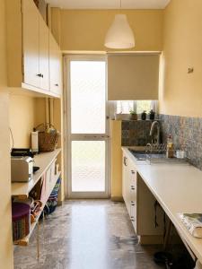 a kitchen with a sink and a large window at Pinetree House in Nafplio