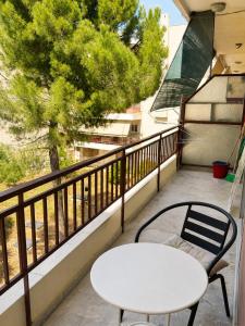 a white table and a chair on a balcony at Pinetree House in Nafplio