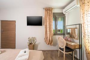 a bedroom with a desk and a television on a wall at Archontiko Haris in Kolymvari