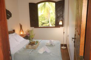 a bedroom with a bed with towels and a window at Hospedagem Arte na Cura in Guarapari +29 photos