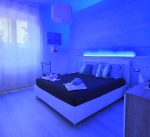 a bedroom with a large bed with blue lighting at Giuly Sole e Sale in Le Grazie