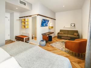 a living room with a bed and a couch at HIAMO Hotel Hamburg-Bergedorf in Hamburg
