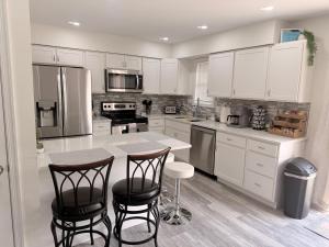 a kitchen with white cabinets and a table and chairs at School Village Walk-in shower and jetted tub in Elizabethtown