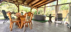 a porch with chairs and a table and a tub at Velencei Odú in Velence