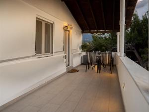 a porch of a house with a table and chairs at Sea & Olive Retreat in Zipárion