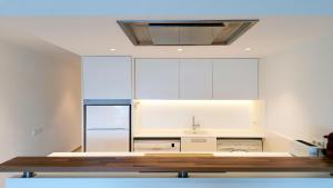 a kitchen with white cabinets and a sink at Apartamento Aqua by VACAY L'Escala in L'Escala