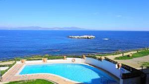 a swimming pool with the ocean in the background at Apartamento Aqua by VACAY L'Escala in L'Escala