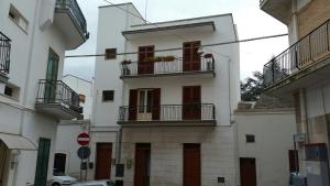 un edificio blanco con 2 balcones en una calle en Il Ciclamino, en Alberobello