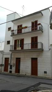 un edificio blanco con ventanas y balcones. en Il Ciclamino, en Alberobello