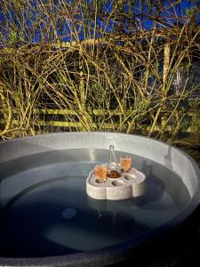 a bath tub with two glasses and a bottle in it at Willows in Rosedale Abbey