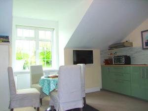 a room with a table and chairs and a kitchen at Glendalough Scenery Farmhouse in Roundwood