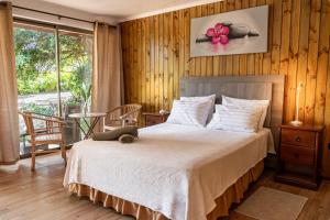 a bedroom with a bed with a flower on the wall at Rapa Nui, La Residence in Hanga Roa