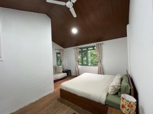 a bedroom with a bed and a ceiling fan at Chara Farmhouse in Kohīma