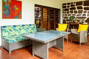 a glass table and chairs in a living room at Rapa Nui, La Residence in Hanga Roa