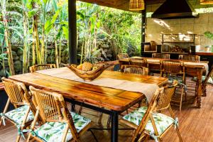 a wooden table with chairs and a bowl of fruit on it at Rapa Nui, La Residence in Hanga Roa