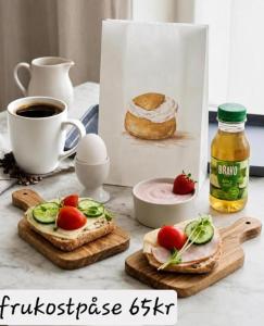 a table with sandwiches and a cup of coffee and a bag of food at Hotell BOULOGNE in Gävle