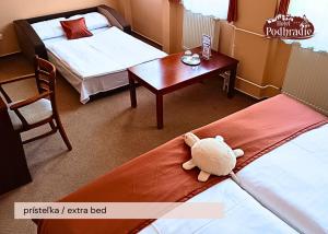 a hotel room with a stuffed animal laying on the bed at Hotel Podhradie in Považská Bystrica +106 photos