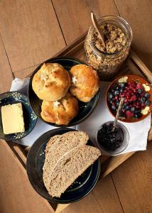 a tray of food with biscuits and bread and berries at La Ferme 1828 in Demi-Quartier