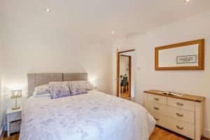 a bedroom with a bed and a dresser and a mirror at 2 Bed in Godshill oc-78573 in Godshill