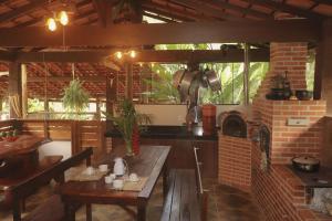 an outdoor kitchen with a table and a brick oven at Hospedagem Arte na Cura in Guarapari