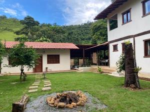 a yard with a fire pit in front of a house at Hospedagem Arte na Cura in Guarapari