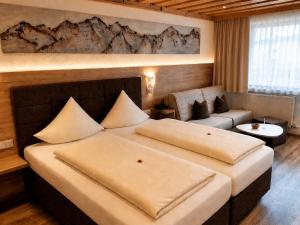 a hotel room with a large bed and a couch at Landhotel Kaserer in Bramberg am Wildkogel +38 photos