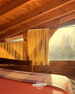 a bedroom with a bed and a window in a wooden cabin at Del Sol a la Montaña EcoLodge - Turismo Consciente in Potrero de Garay +110 photos