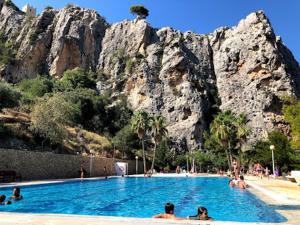 people in a swimming pool in front of a mountain at Sunset in Guadalest in El Castell de Guadalest