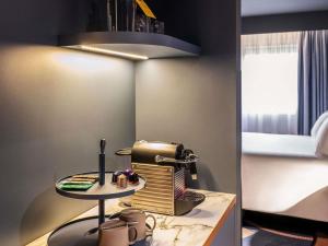 a room with a table with a sewing machine at TRIBE Hotel Den Haag Centraal - Opened December 2025 in The Hague