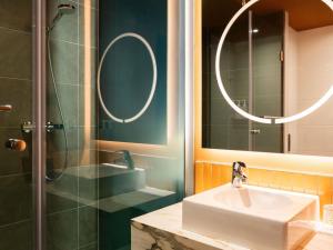 a bathroom with a sink and a shower at TRIBE Hotel Den Haag Centraal - Opened December 2025 in The Hague +143 photos
