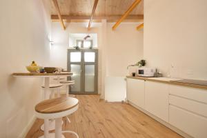 a kitchen with white cabinets and a counter with stools at B&B Ago e Luce - YourPlace Abruzzo in Vasto