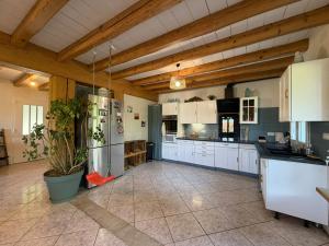 a large kitchen with white appliances and wooden ceilings at La maison d'Artzamendi in Louhossoa