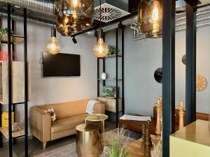 a living room with a couch and a tv at HIAMO Hotel Hamburg-Bergedorf in Hamburg
