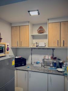 a kitchen with white cabinets and a counter top at Cozy Poolside Condo Near BTS All Amenities in Sathani Ban Hua Mak +4 photos