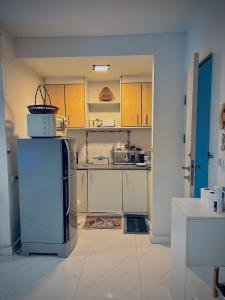a kitchen with a refrigerator in a room at Cozy Poolside Condo Near BTS All Amenities in Sathani Ban Hua Mak
