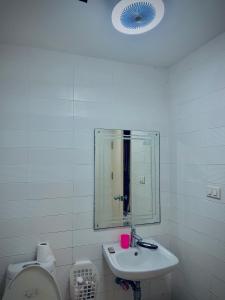 a bathroom with a sink and a mirror and a toilet at Cozy Poolside Condo Near BTS All Amenities in Sathani Ban Hua Mak