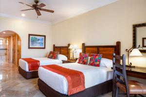 a bedroom with two beds and a desk and a table at Villa la Estancia Beach Resort & Spa in Cabo San Lucas +54 photos
