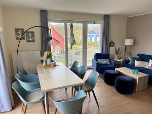 a living room with a table and blue chairs at Anker 39 in Plau am See