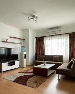 a living room with a couch and a flat screen tv at RiX Sunny Apartments in Kyrenia